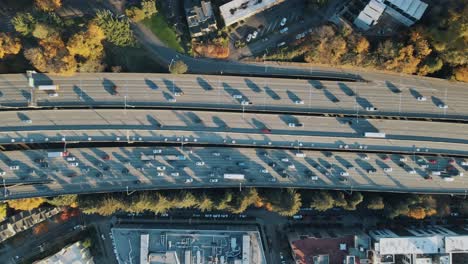 Más-Tarde,-El-Tráfico-En-Una-Autopista-De-Varios-Carriles-Congestionado-En-El-Centro-Urbano-Durante-El-Otoño,-Drones-De-Arriba-Hacia-Abajo