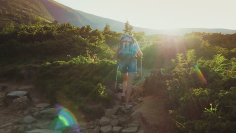 A-Female-Tourist-With-A-Backpack-With-Trekking-Sticks-Goes-Up-The-Montaña-Path-In-The-Rays-Of-The-S