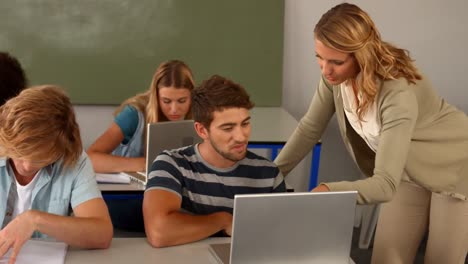 Teacher-helping-student-with-laptop