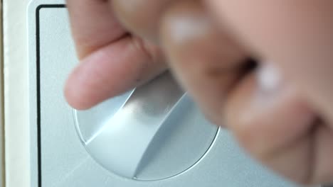 hand turning a silver light switch