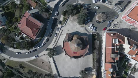 aerial orbit and cinematic soaring view of historical santo amaro chapel surrounded by mosaic floor, portugal