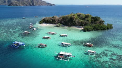 tour boats at reef of cyc island in coron, aerial orbit shot