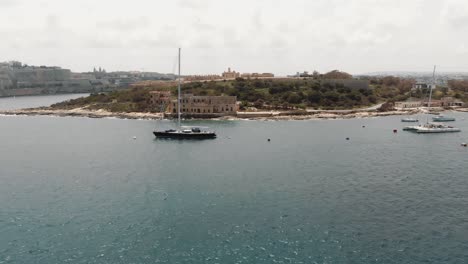 manoel island coast line from the tigné seafront in sliema city in malta - ascending wide aerial shot