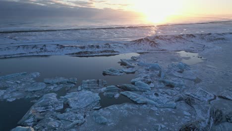 Vivid-sunset-over-glacier-lagoon,-illuminating-ice-floes,-South-Iceland