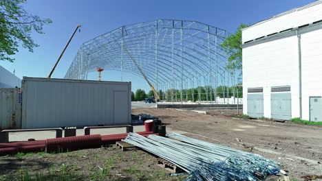 metal frame for the construction grain warehouse with heavy machinery and equipment