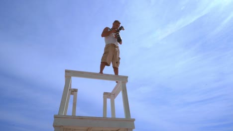 fotógrafo tomando una foto desde la torre de vigilancia. hombre usando una cámara profesional