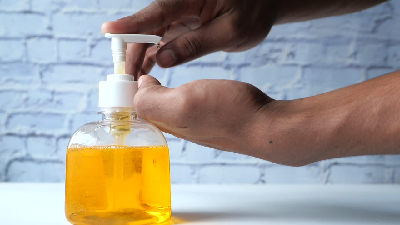 persona que utiliza el dispensador de jabón para manos