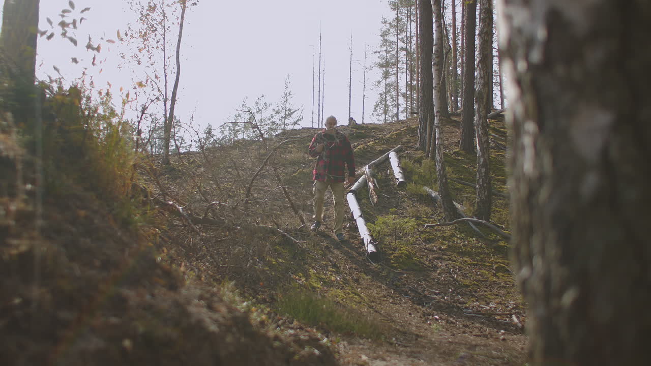 hombre cansado está perdido en el bosque caminando solo entre los árboles en el día de otoño recolector de hongos o excursionista solitario