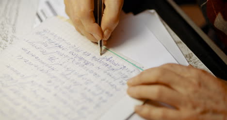 Senior-Businessman-Writing-On-Paper-At-Table-In-Office-14