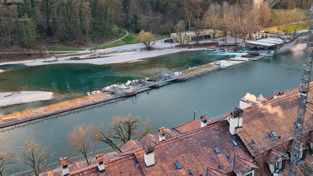 Blick über die Dächer des Matte-Quartiers von Bern und das Schwellenmätteli am Aare-Wehr an einem kalten Wintertag. Die Aare führt wenig Wasser und schafft so eine ruhige städtische Flusslandschaft in der Schweiz.