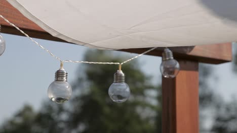 wedding decoration - composition of lamps and white scarfs waving in the wind in the sun