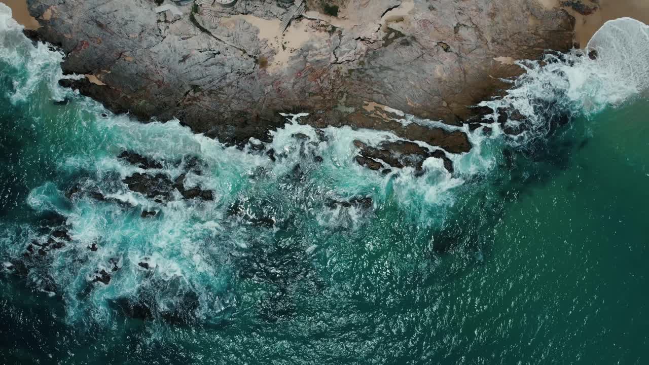 Riprese aeree di onde che si infrangono contro una costa rocciosa a Cabo San Lucas.