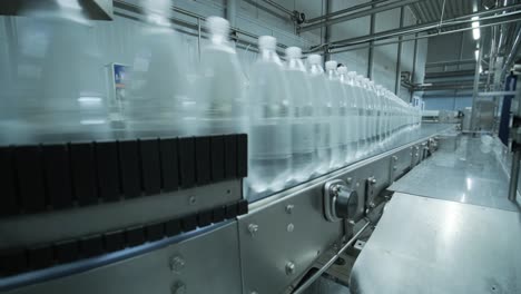 cinta transportadora con botellas de agua potable en una planta de bebidas moderna