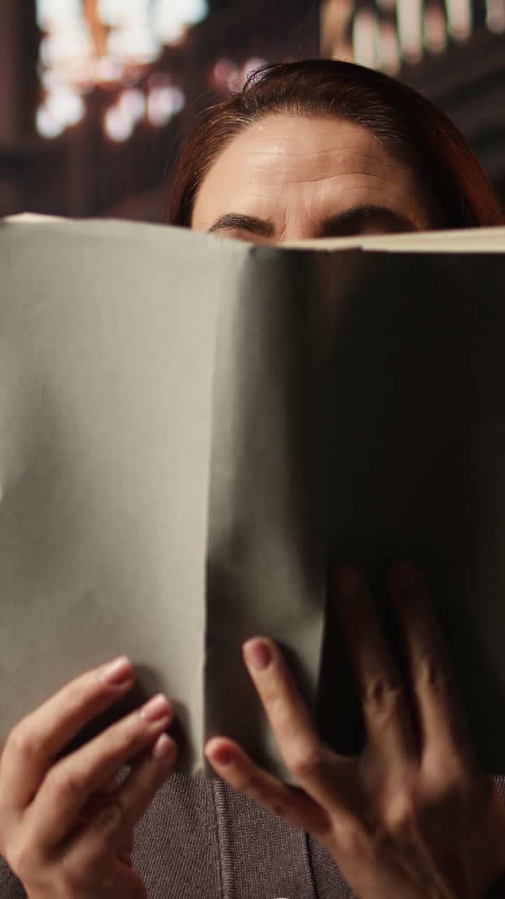 Vertical Video Mature person enjoying lecture at a public library and reading many books