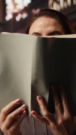 vertical video mature person enjoying lecture at a public library and reading many books
