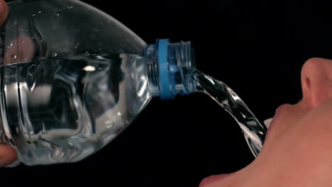 woman pouring water into her mouth