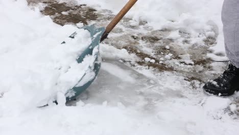 close up of person shoveling snow outdoors on winter day