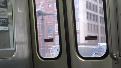 View-looking-out-of-train-doors-at-city