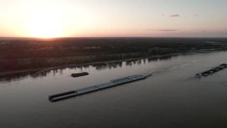 Aerial-tracking-shot-of-Missisippi-River-barge-during-golden-sunset