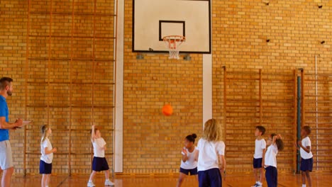 basketball coach teaching basketball to schoolkids in basketball court 4k