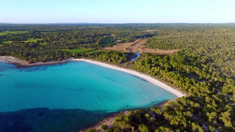 Vista-Aérea-De-La-Playa-De-Son-Saura-Con-Agua-Azul-Clara-En-Menorca-España,-Tiro-De-órbita-Amplia