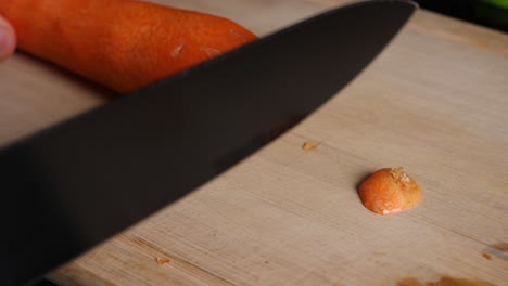 cutting of the front and back of a carrot in slow motion on a chopping board