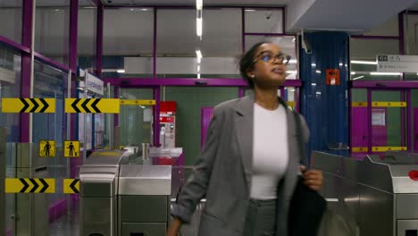 woman walking through subway station gate