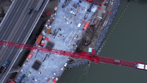 Crane-by-busy-highway-bridge-construction-zone-above-rotating