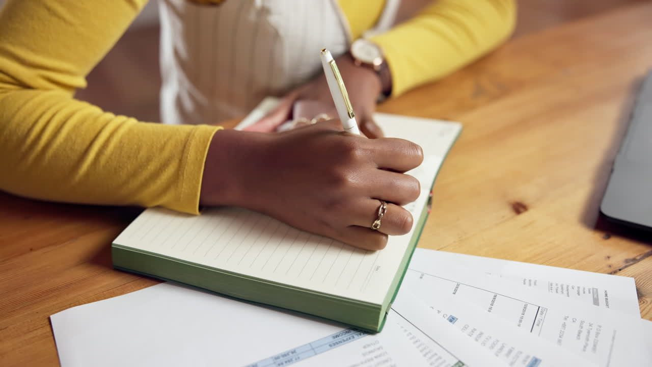 mujer escribiendo en un cuaderno en su escritorio