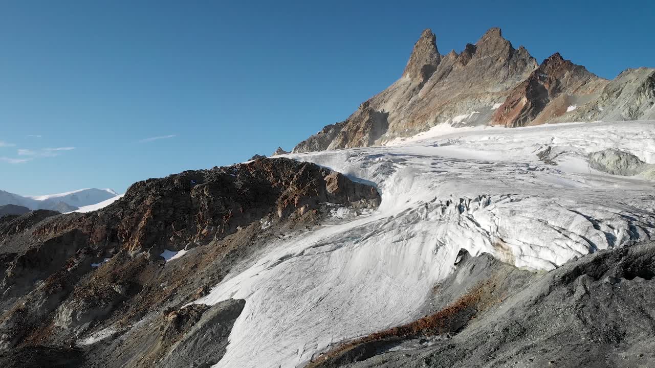 vista aérea de un glaciar cerca de arolla en valais, suiza con los picos de aiguilles rouges iluminados por el sol de la mañana temprano