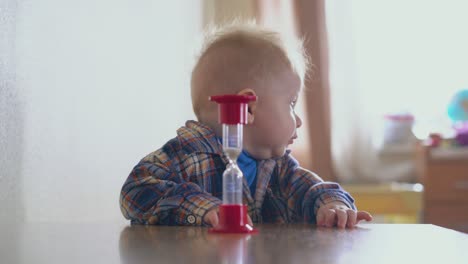 son-throws-down-sandglass-from-table-and-mommy-in-room