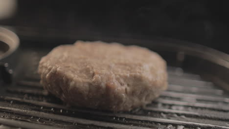 beef or chicken burger on grill being prepared for a delicious burger sandiwich , with a black background and simple light set up shot on raw 4k