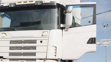 cuc worker with vest and cap getting on a truck in a logistics park