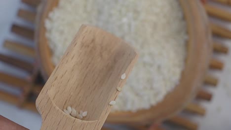 white sesame seeds in wooden scoop
