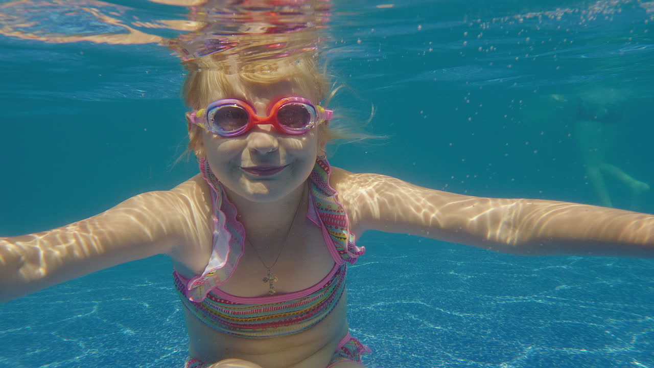 6세 소녀는 수영장 슬로우 모션 비디오에서 다이빙하는 법을 배웁니다.