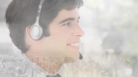 Animation-of-businessman-using-phone-headset-and-smiling-over-cityscape