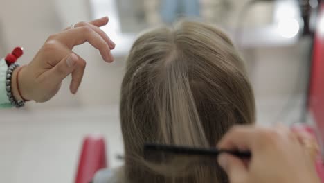 a woman is getting her hair done at a salon.