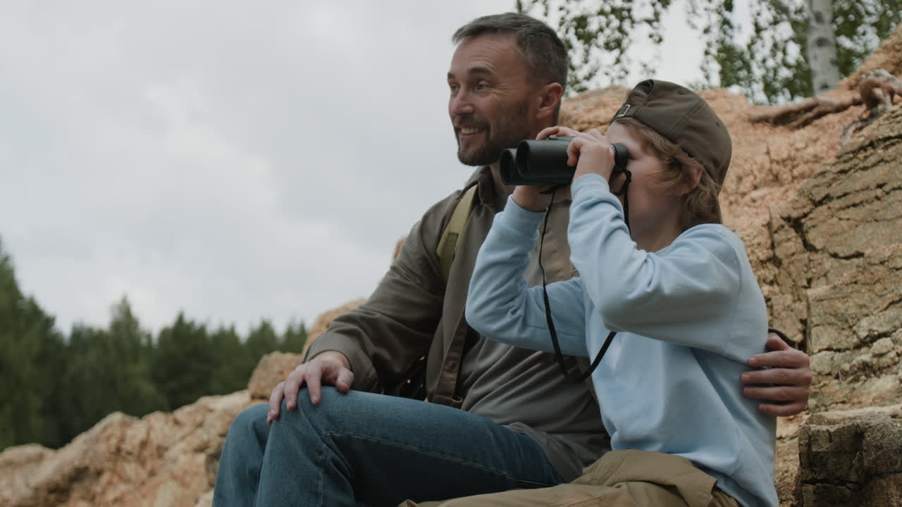 Father and Son Exploring Nature with Binoculars