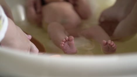 Mother-with-elder-child-bathing-newborn-baby