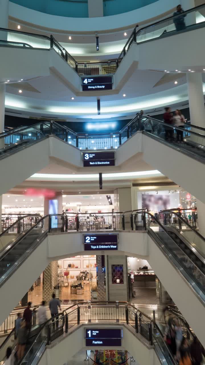 Mennesker på rulletrapper i et moderne indkøbscenter