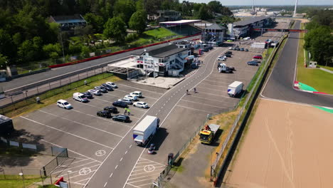 People-gather-to-race-track-and-preparing-for-race,-aerial-view