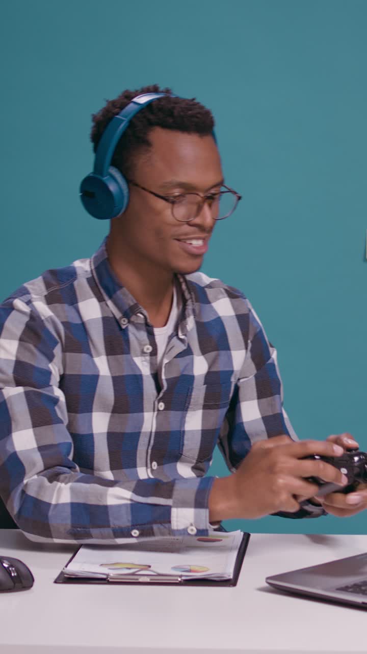 Mand, der spiller computerspil med headset på kontoret