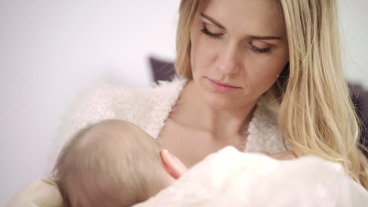 Young mother breast feeding new born child. Enjoy motherhood