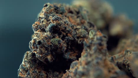 A-macro-cinematic-detailed-shot-of-a-cannabis-plant,-orange-hybrid-strains,-Indica-and-sativa-,-purple-marijuana-flower,-on-a-rotating-stand,-super-slow-motion,-120-fps,-Full-HD,-studio-pro-lighting