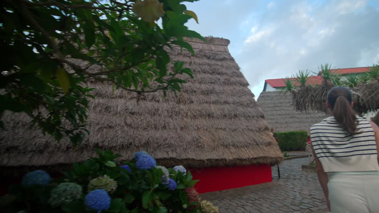 chica modelo caminando por las casas tradicionales en forma de a en santana en portugal madeira