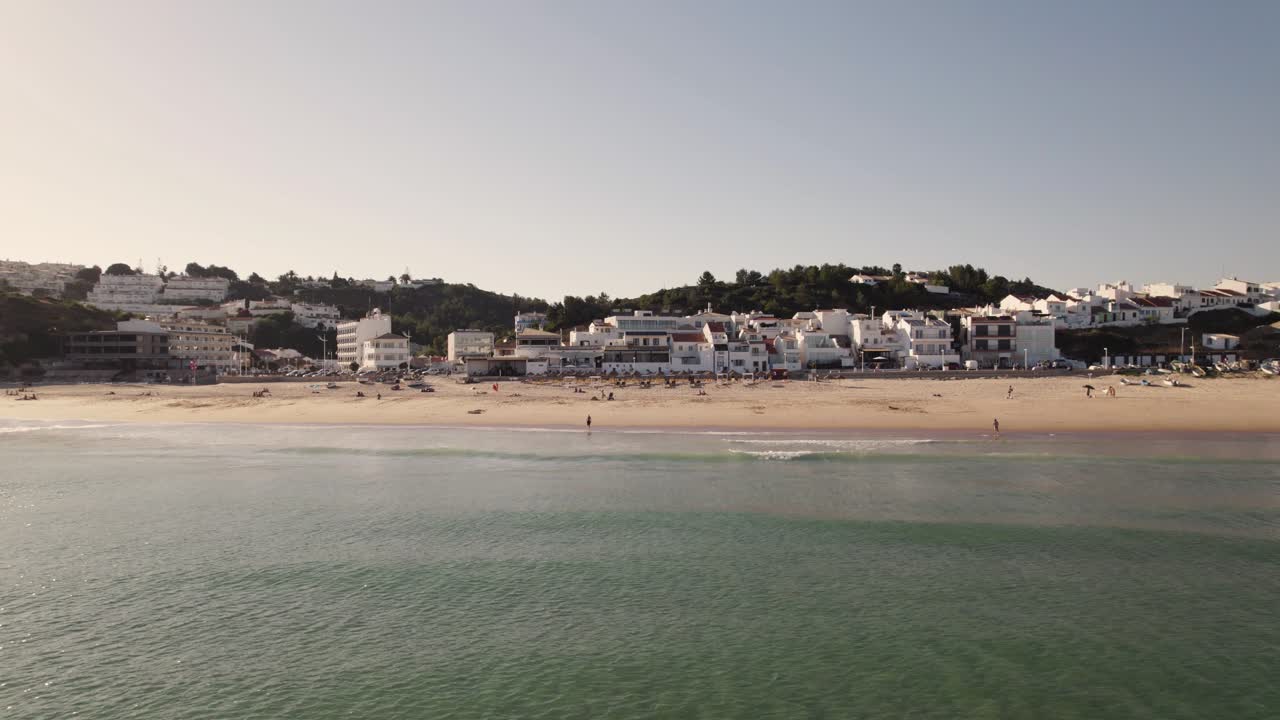 vista aérea cinematográfica de las ondas de las olas del océano atlántico en la playa praia da salema en algarve portugal