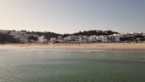 Cinematic-aerial-view-of-Atlantic-Ocean-wave-ripples-at-Praia-da-Salema-beach-in-Algarve-Portugal