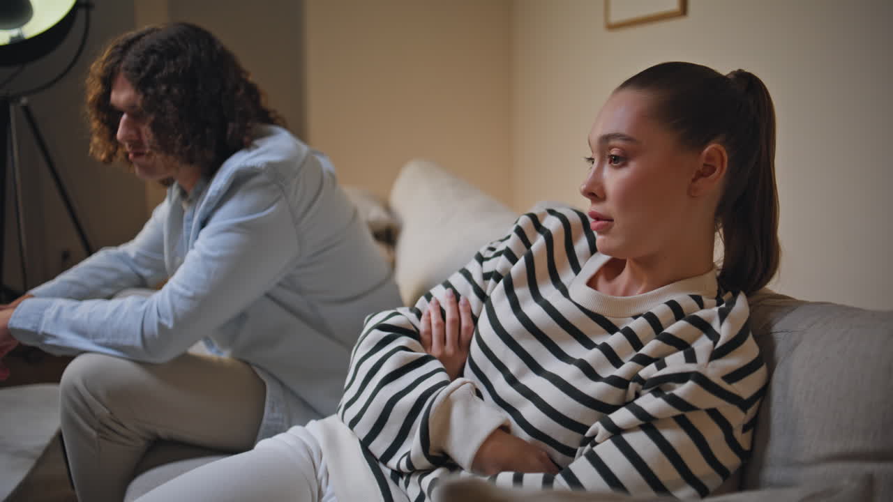 Unhappy spouses complaining problem in marriage sitting apartment sofa closeup