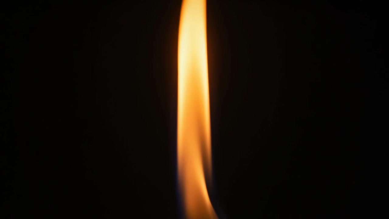 Filming vertical flame narrowing and forming bulb in dark studio, responding to draft at wick