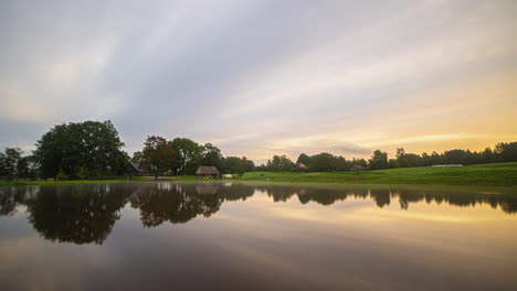 Going-from-spring-to-summer,-autumn-and-winter-in-a-time-lapse-of-a-lake-with-a-holiday-home